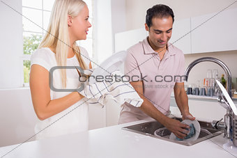Happy couple washing dishes together