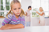 Little girl looking sad in front of fighting parents