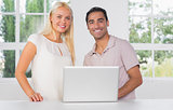 Smiling couple using laptop