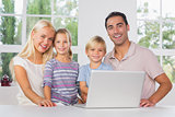 Happy family using a laptop together