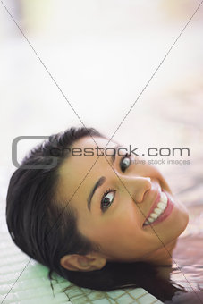 Pretty smiling woman lying in a jacuzzi