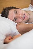 Handsome man smiling in bed