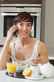Woman having breakfast while on the phone