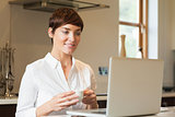 Woman using laptop and drinking coffee