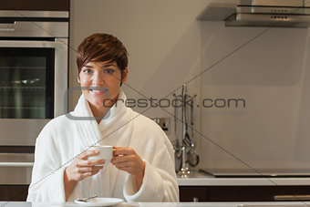 Woman drinking a coffee in kitchen