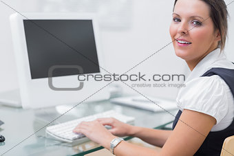 Confident female executive using computer at office