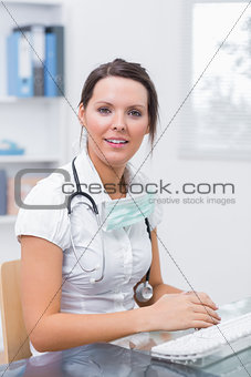 Doctor sitting in front of computer at clinic