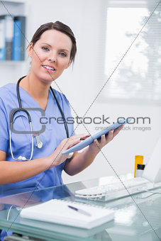 Portrait of female surgeon using digital tablet at clinic