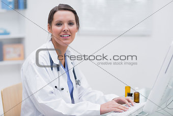 Portrait of smiling female doctor using computer