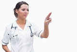 Portrait of female nurse pointing at invisible screen