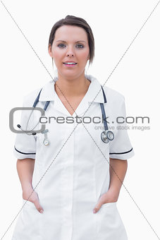 Portrait of smiling nurse standing with hands in pockets