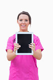 Portrait of young nurse holding out digital tablet