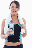 Portrait of woman in sportswear holding towel around neck and water bottle
