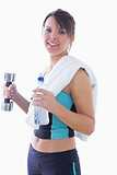 Portrait of young woman holding dumbbell and water bottle
