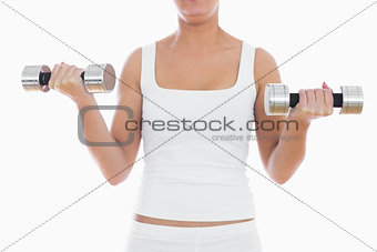Midsection of woman exercising with dumbbells
