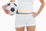 Midsection of fit woman in sportswear with football