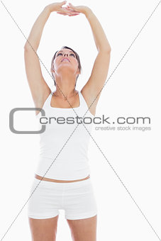 Young woman in sportswear holding hands up together