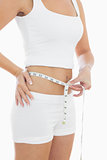 Midsection of woman measuring waist