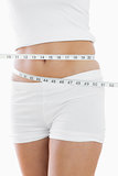 Closeup midsection of woman measuring waist