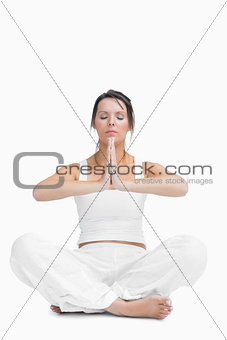 Young woman with crossed legs in praying position