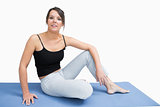 Portrait of young woman in sportswear sitting on yoga mat