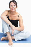 Portrait of woman in sportswear sitting on yoga mat