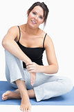Portrait of young woman in sportswear sitting on yoga mat