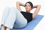 Portrait of woman doing situps on exercise mat over