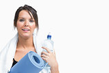 Portrait of woman holding water bottle and exercise mat