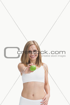 Portrait of happy woman showing a green apple