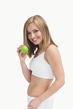 Portrait of happy young woman holding green apple