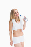 Happy young woman with towel around neck holding water bottle