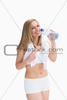 Portrait of smiling woman with towel around neck drinking water