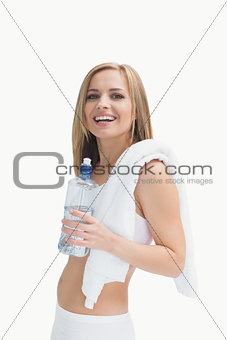 Portrait of happy woman with towel holding water bottle