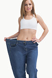 Portrait of young woman wearing old pants after losing weight