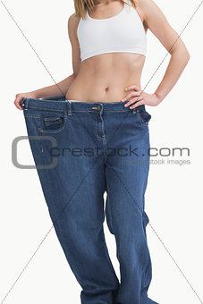 Young woman wearing old pants after losing weight