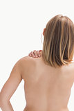Rear view of topless young woman with shoulder pain