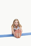 Portrait of happy woman performing stretching exercise on yoga mat