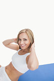 Portrait of happy woman doing situps on exercise mat