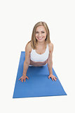 Portrait of happy woman doing pushups on exercise mat