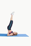 Side view of woman in the shoulder stand position on yoga mat