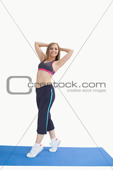 Portrait of happy woman posing on exercise mat