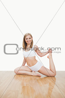 Portrait of young woman doing physical exercise on hardwood floor