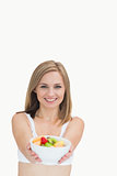 Portrait of woman offering you bowl of fruits