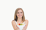 Portrait of young woman offering you bowl of fruits