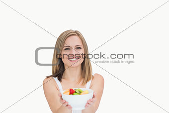 Portrait of young woman offering you bowl of fruits