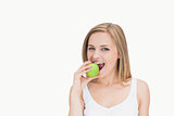 Portrait of young woman eating green apple