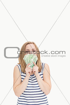 Happy young woman kissing fanned dollars