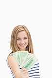 Portrait of happy young woman holding out fanned dollar banknotes