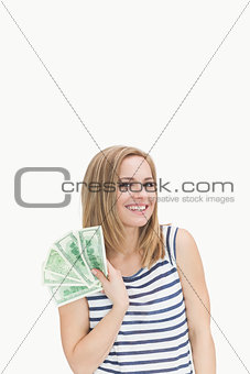 Portrait of happy young woman with fanned dollars